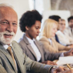 Group of professionals sitting at table.